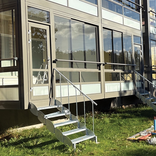 Brf Bergsbygårdar i Skellefteå med nya moderna och energieffektiva balkonger från Balco. Balkongerna har trappor ut mot trädgården.